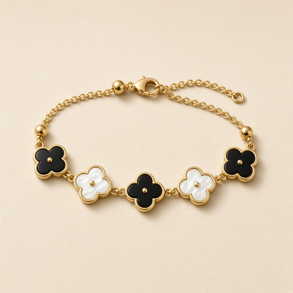 Gold bracelet with black and white four leaf clover charms
