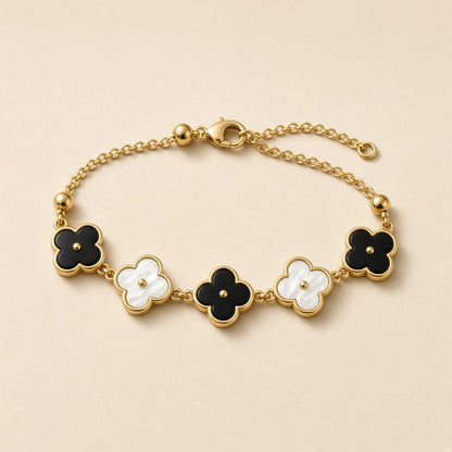 Gold bracelet with black and white four leaf clover charms