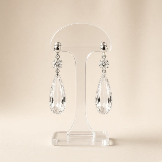 Silver crystal teardrop dangle earrings on a display stand