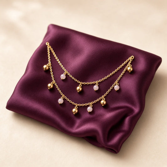 Pair of dainty gold anklets with bead and bell charms