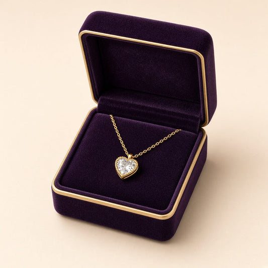 Tiny gold heart pendant with crystal inside a plum gift box